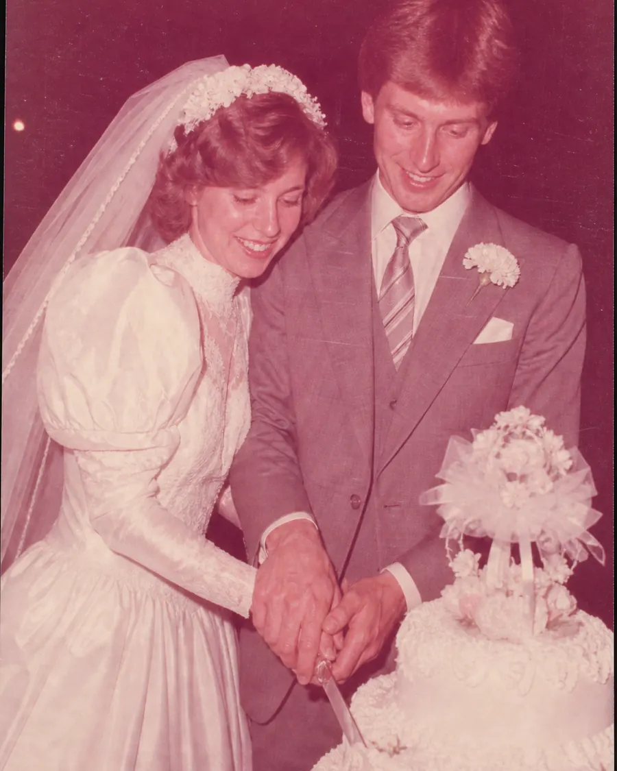 Trouwfoto uit 1986: het paar snijdt samen de bruidstaart aan; de hele afdruk is naar rood en roze gekanteld.